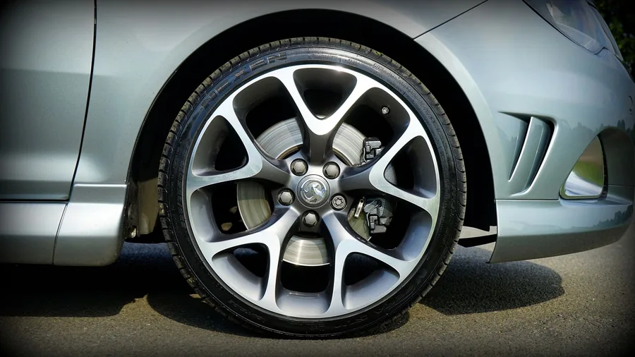 Close-up of a car alloy wheel and tyre on a UK-registered hatchback