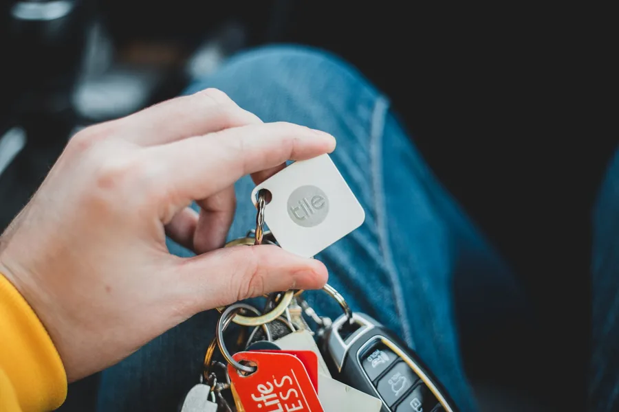 A hand holding a car key with a blank tag
