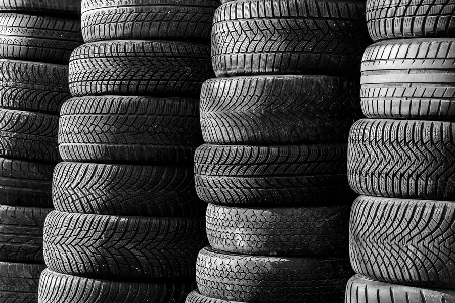 Racks of new tyres stacked in rows inside a tyre shop
