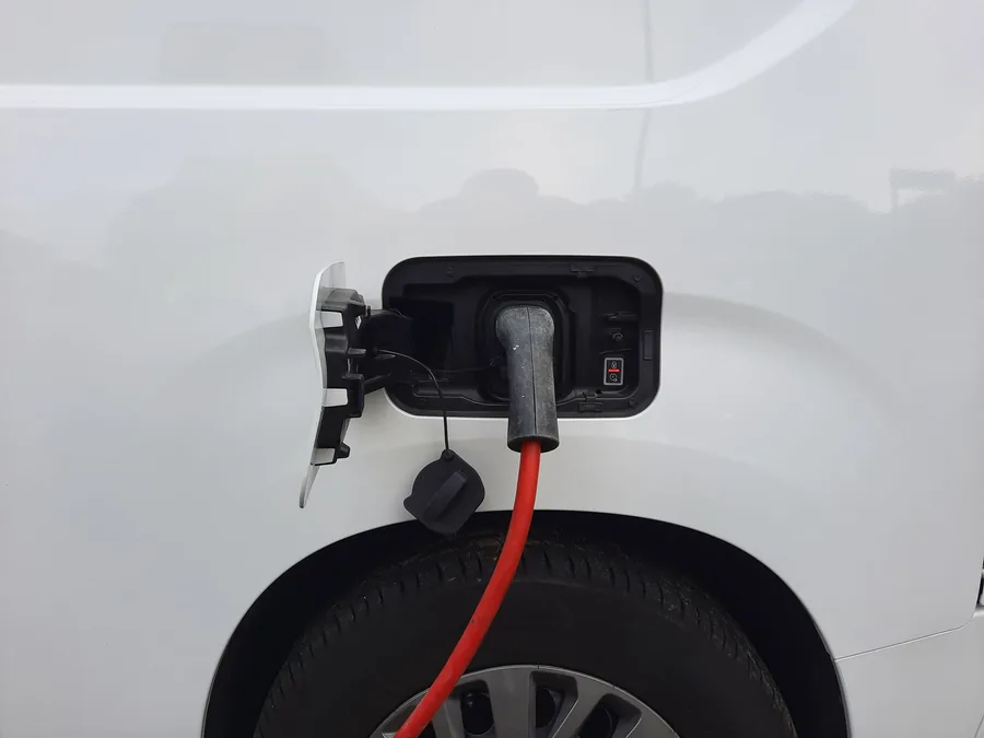 An electric car's charging port with a cable plugged in