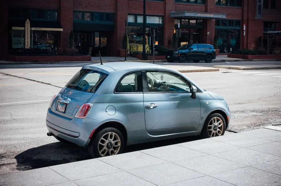 A small hatchback parked at the kerb on a city street