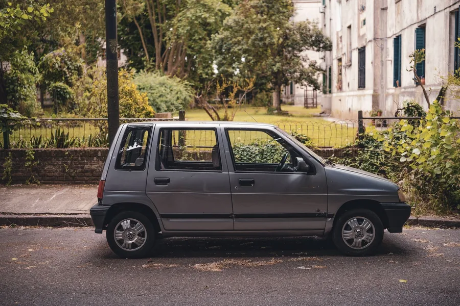 A small petrol city car parked on a residential street