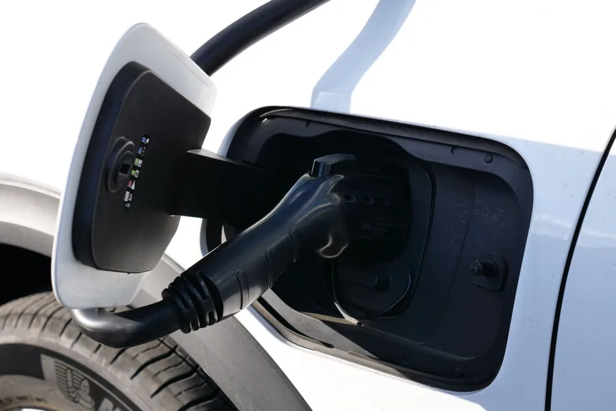 A charging connector plugged into an electric car's charge port