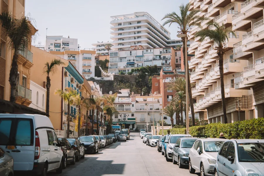 Cars parked on a steep street in a Spanish coastal town