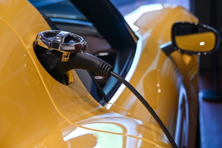 A charging cable plugged into the charging port of an electric car