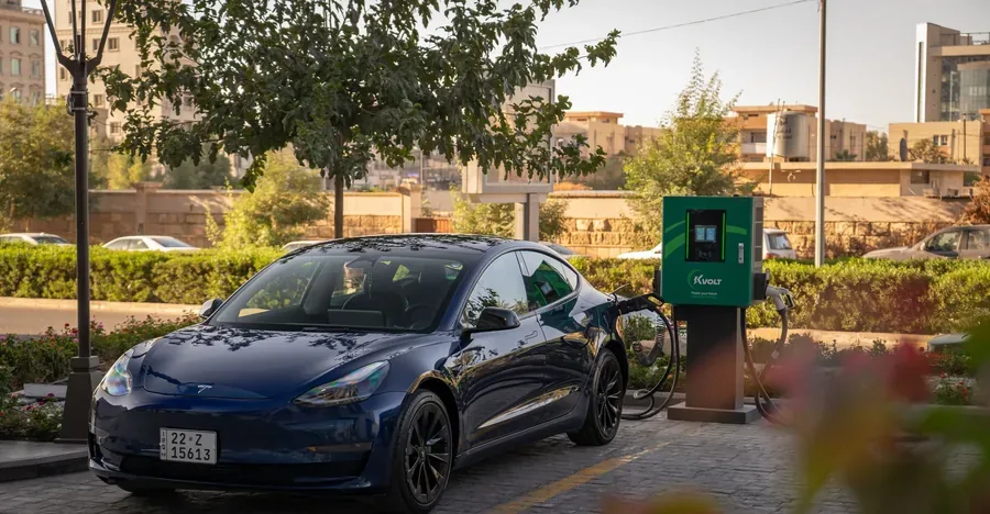 A Tesla Model 3 plugged in at a public charging station