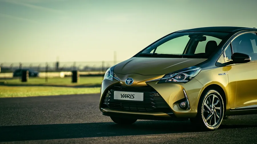 A Toyota Yaris parked on a sunlit road