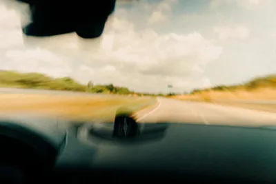 View through a car windscreen of a rural road at speed