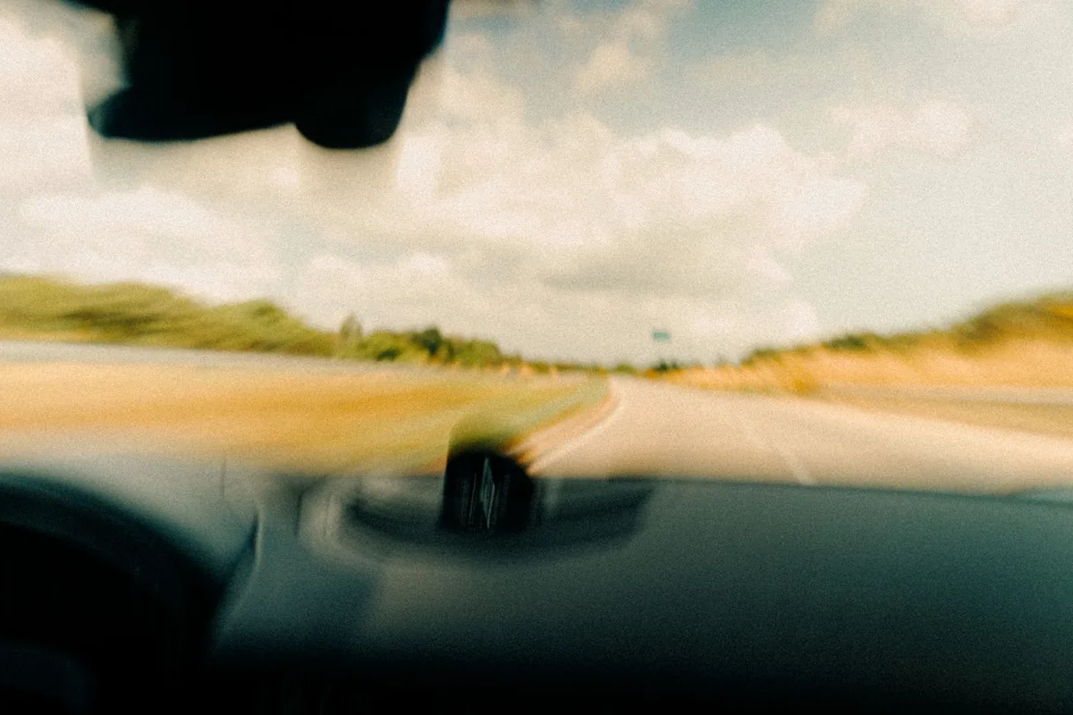 View through a car windscreen of a rural road at speed