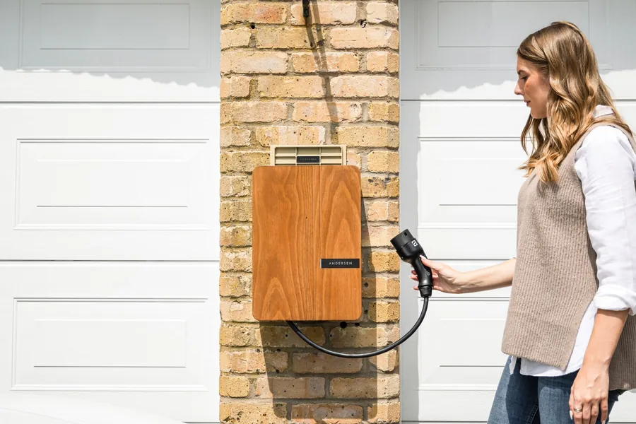 A woman plugging a home wall charger into an electric car