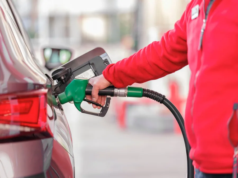 A fuel nozzle refuelling a car at a filling station