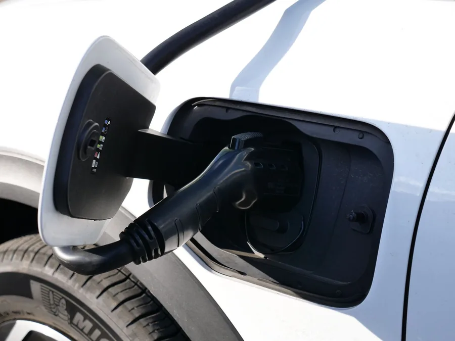 A charging cable plugged into an electric car's charge port