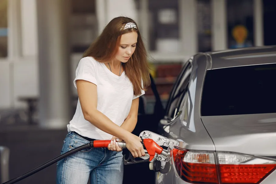 A driver refuelling a car at a petrol station during the day