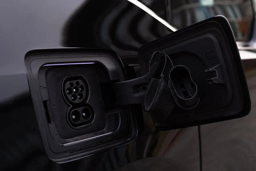 Close-up of an electric vehicle charging port with the charge flap open