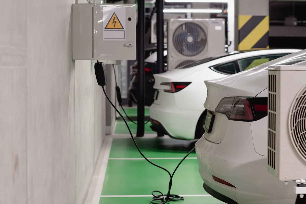 Electric cars plugged in at a row of public charging bays