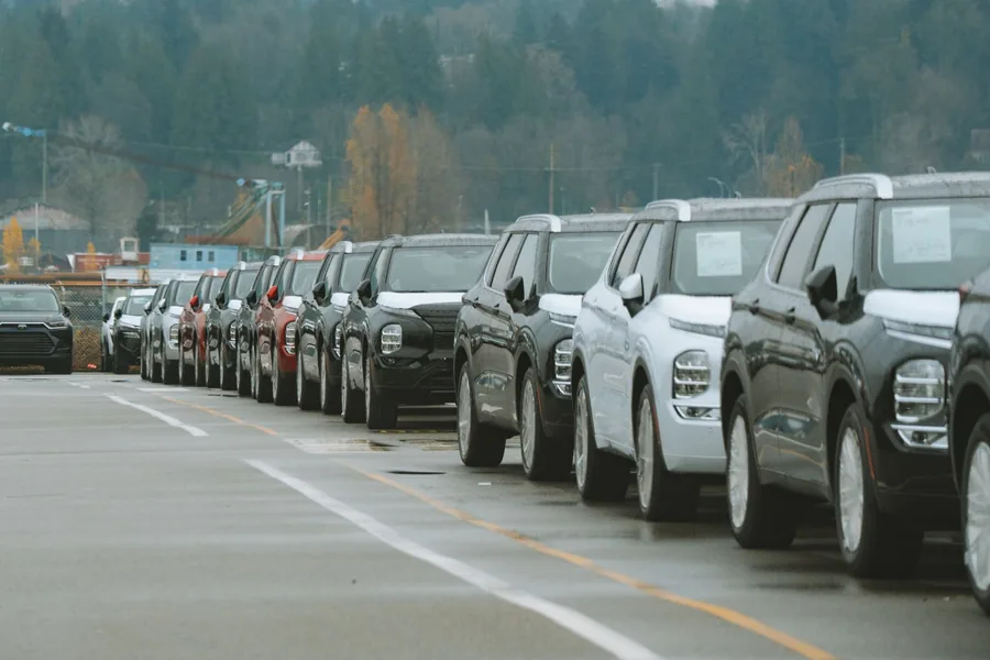 A row of used cars lined up for sale on a paved lot