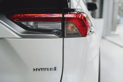 A chrome HYBRID badge on the rear panel of a white car