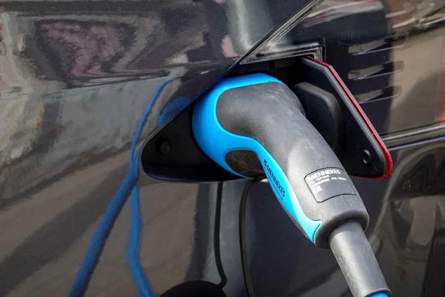 An electric car charge connector plugged into the charging port
