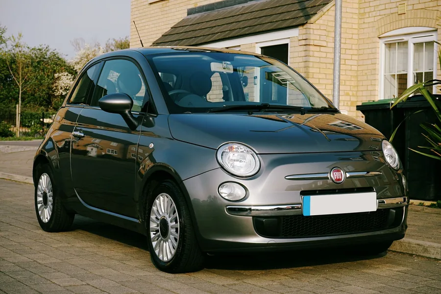 A small petrol hatchback parked outside on a residential street