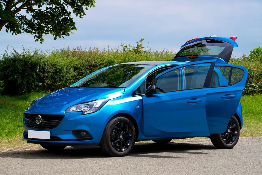A blue family hatchback parked on a roadside verge