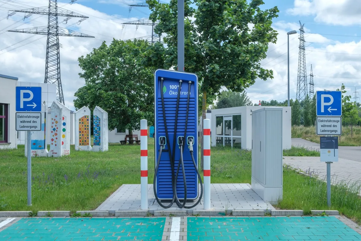 Free-standing public EV charging point with three cables and marked parking bays