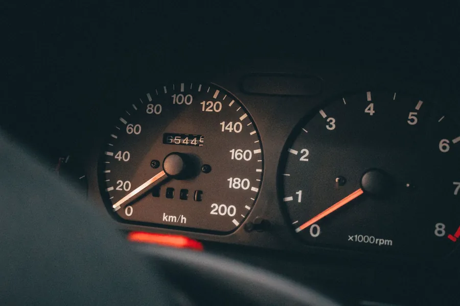 A car instrument cluster showing the digital odometer reading beside the gauges