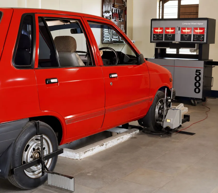 Car on a workshop lift with wheel alignment equipment attached to the wheels