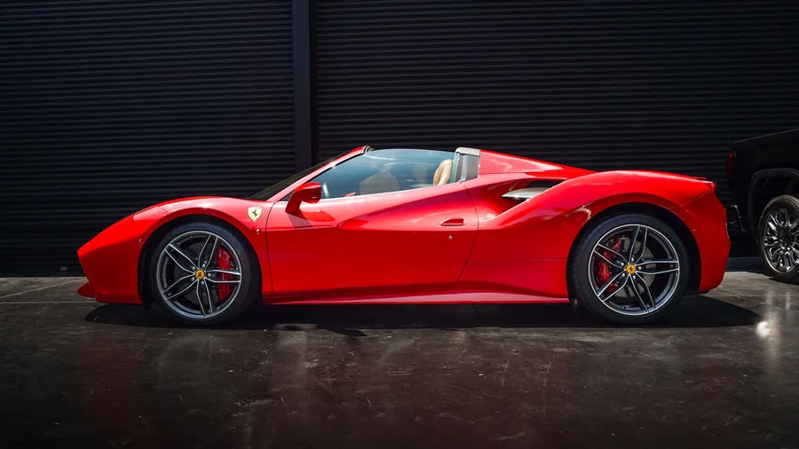 A red supercar parked on a city street