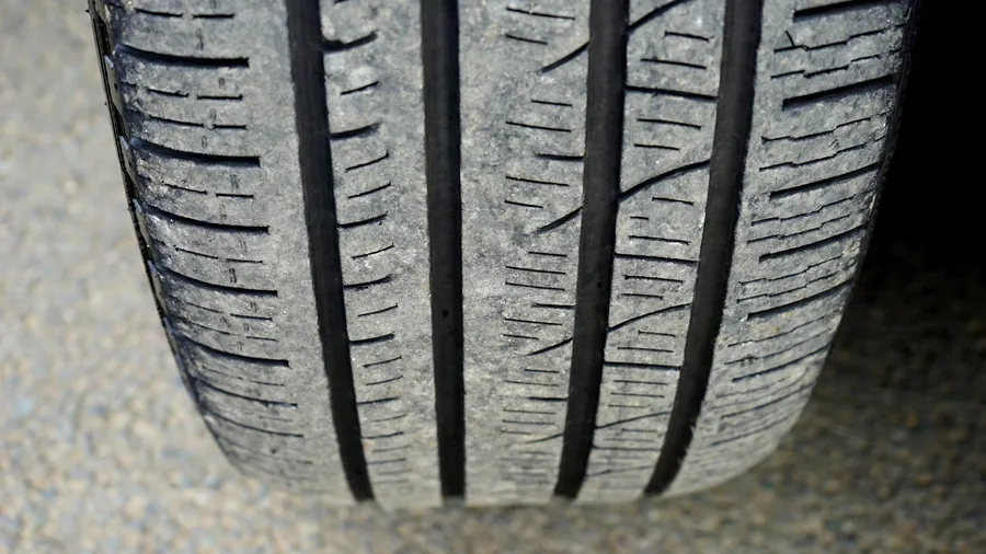 Close-up of a car tyre tread showing grooves and the tread wear indicators